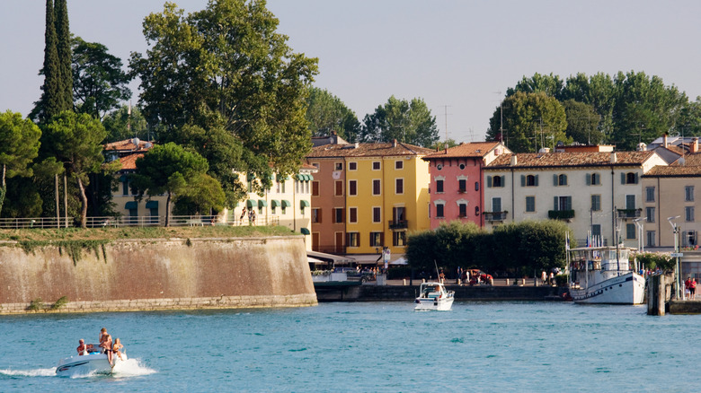 Boat leaving the fortifications and town of Peschiera del Garda, Italy