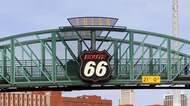 A Route 66 sign attached to a pedestrian overpass bridge in Tulsa, Oklahoma