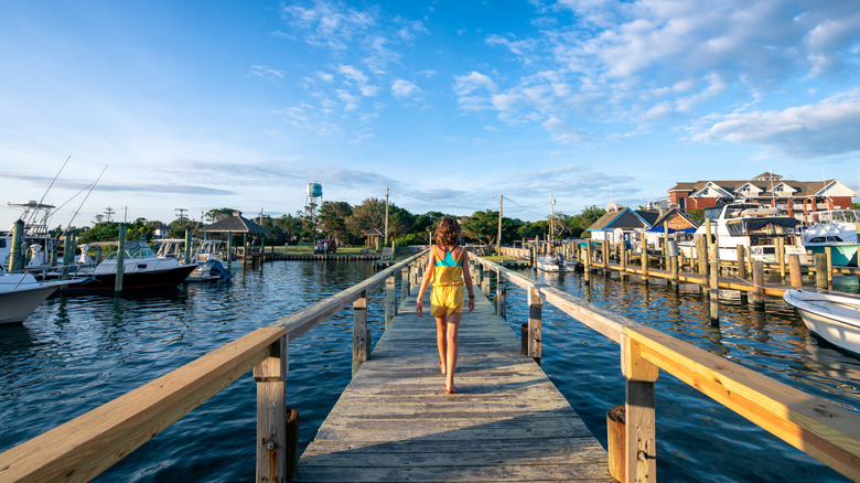 Girl walks down a wooden dock in Ocracoke village