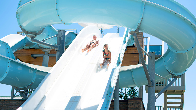 Kids going down a slide at a waterpark