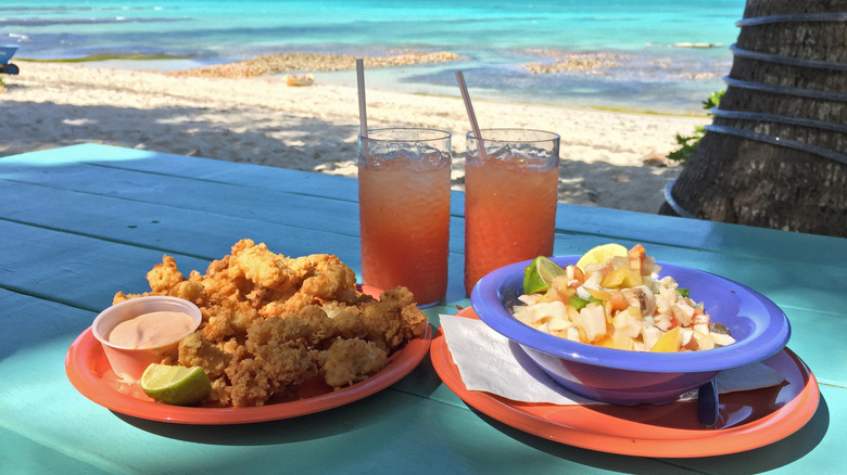 Plates of conch fritters and conch salad on the beach