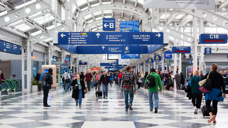 People walk through busy Chicago O'hare airport terminal