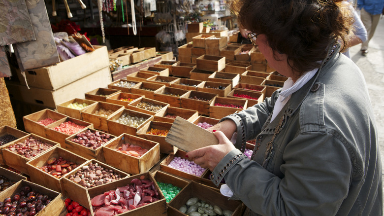 A person looking through boxes of beads in a Parisian flea market.