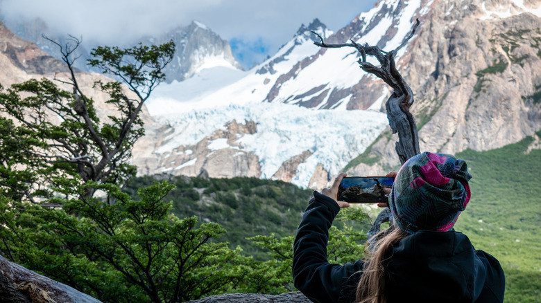 Woman taking a photo of mountains