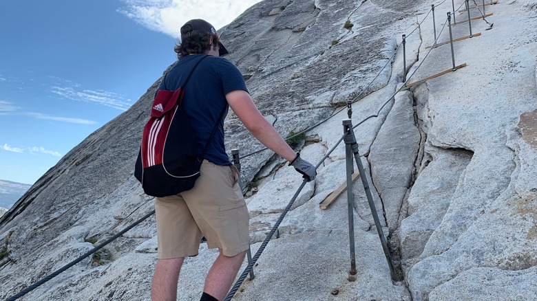 A hiker scaling up the cables section of Half Dome