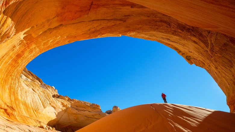 Man standing on rolling sand dune at the Great Chamber, Utah