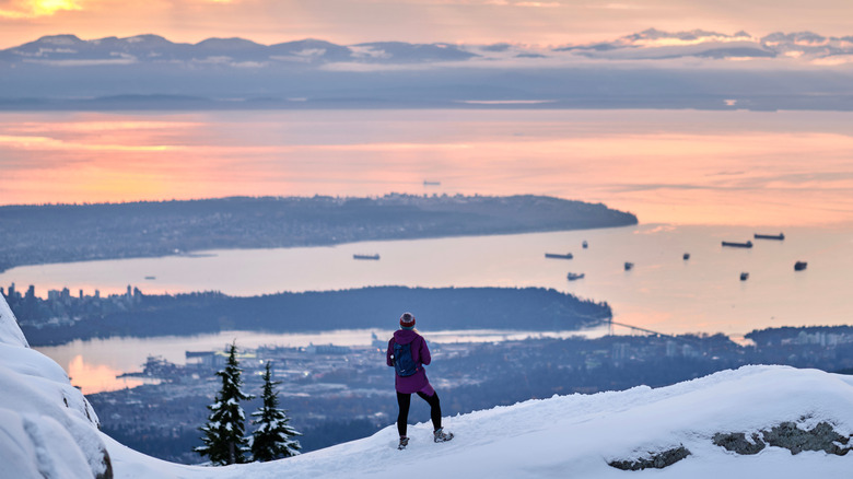 Snowshoer overlooking Vancouver from Mt. Seymour at sunset