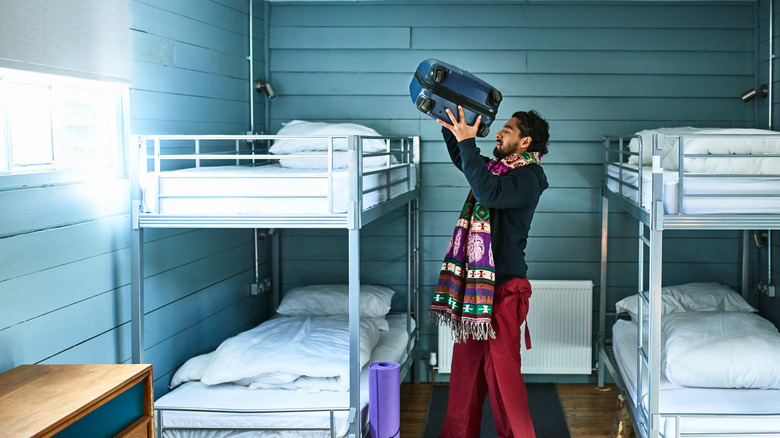 Man at a hostel with suitcase