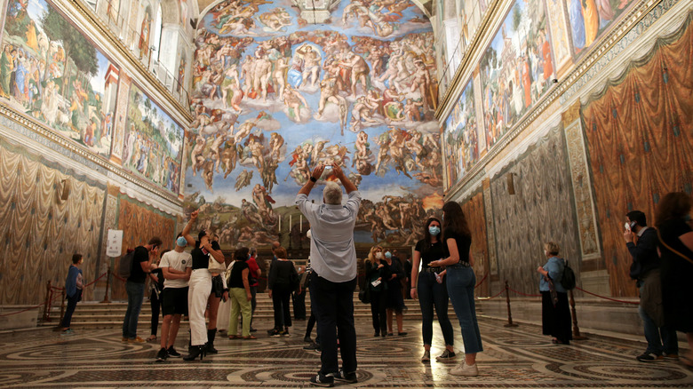 A visitor to the Sistine Chapel takes a photo with their phone