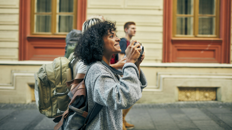 Traveling woman holding a camera on European street