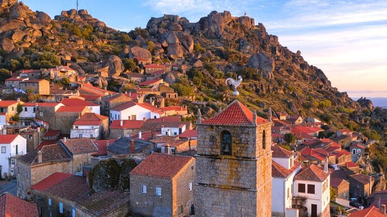 Stone houses with red roofs and rocky mountainside in Monsanto