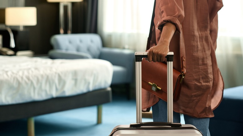 Woman with suitcase in room