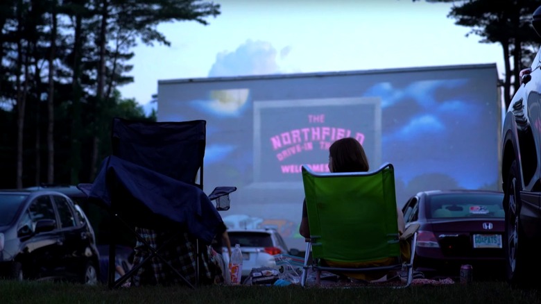 Woman sitting in portable chair at Northfield Drive-in