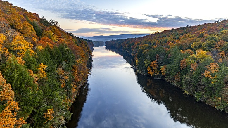 Connecticut River in fall between hills of orange and green