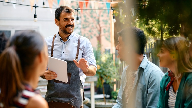 Waiter talking to customers at a restaurant