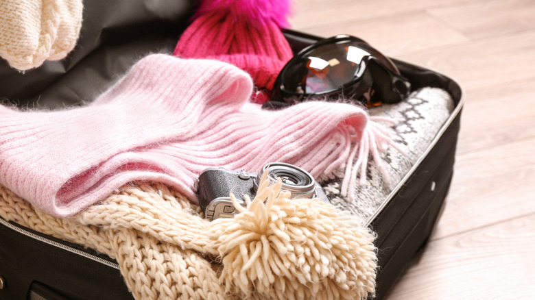 Suitcase packed with items for winter