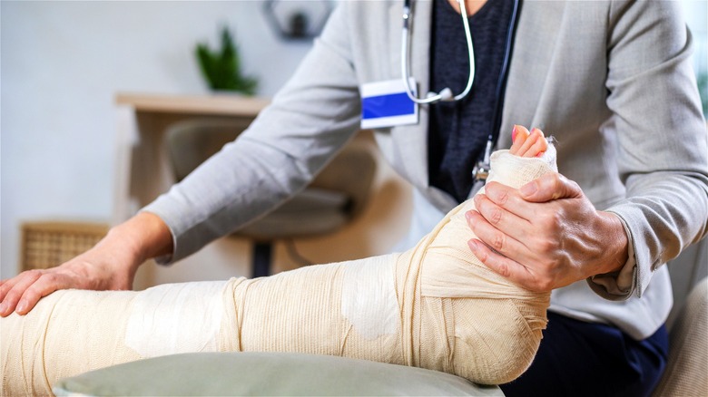 Doctor examining a leg in a cast