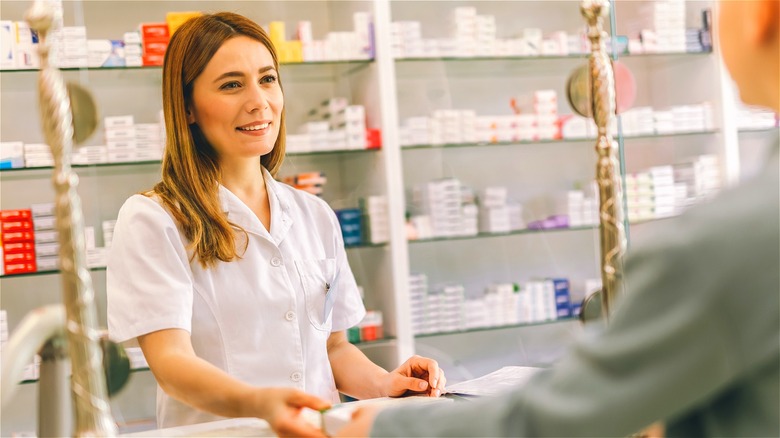 Pharmacist giving medicine to a customer