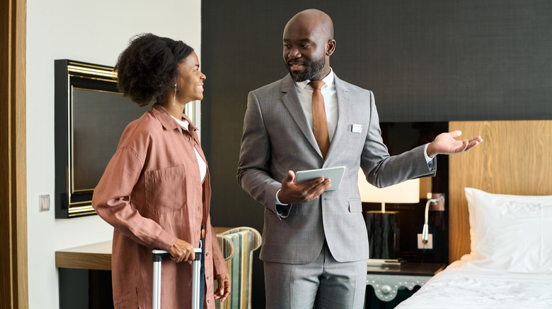 Young woman being welcomed to her hotel room