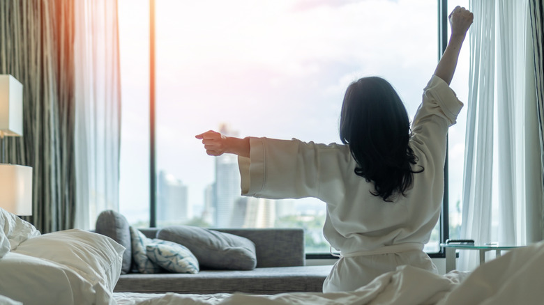 Woman waking up in a hotel room