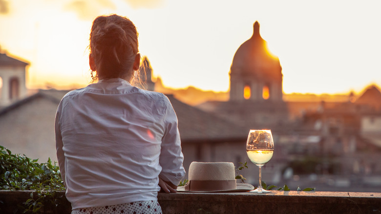 Woman drinking wine looking at Rome