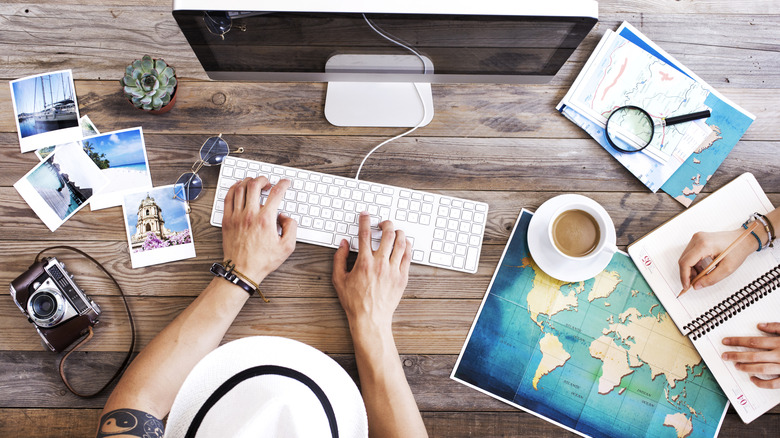 Person using various resources to plan a vacation