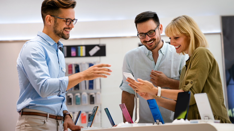 A couple receives help from phone store staff