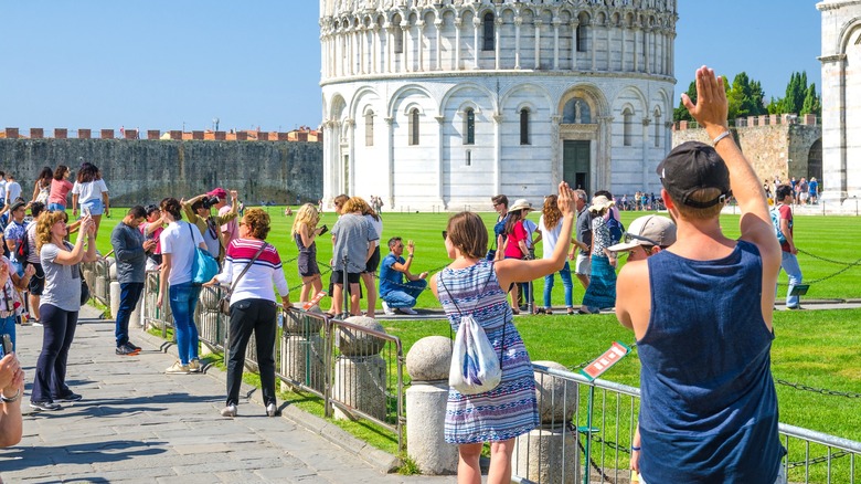 Tourists posing at leaning tower of Pisa