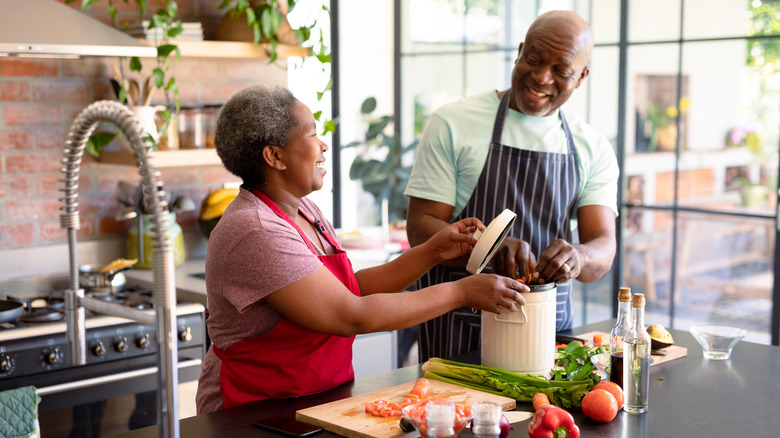 A happy older couple cooking fresh food together