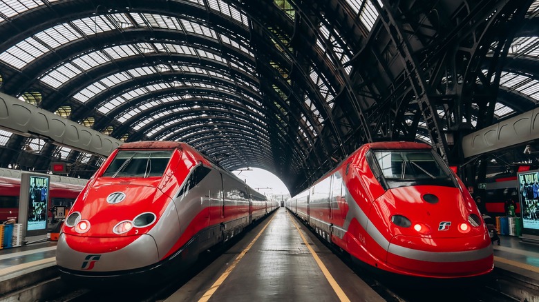 red trains at a station in Milan, Italy