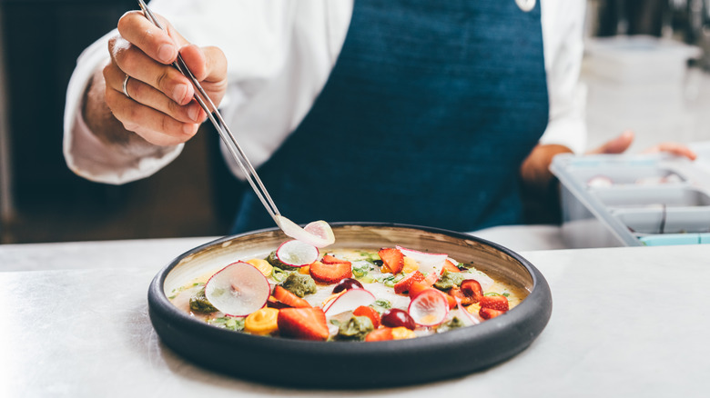 Chef putting the finishing touches on a salad at a fancy restaurant