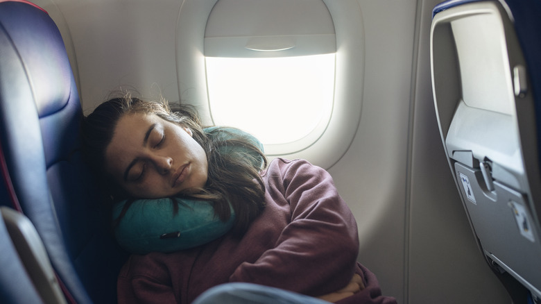 Woman sleeping with neck pillow on airplane