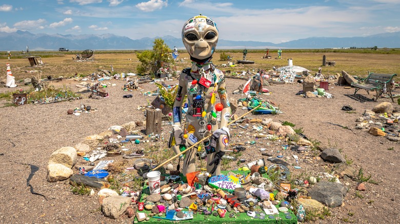 Random objects on an alien statue in the desert