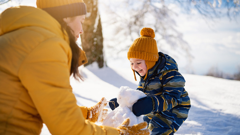 Mother and child making a snowman together