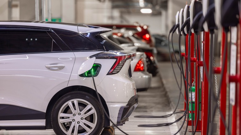 Row of EV chargers with car plugged in and charging.