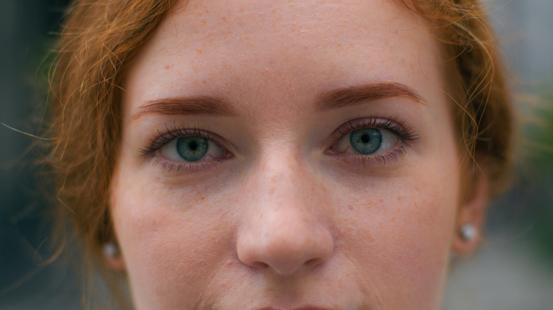 A redheaded girl with wide blue eyes.