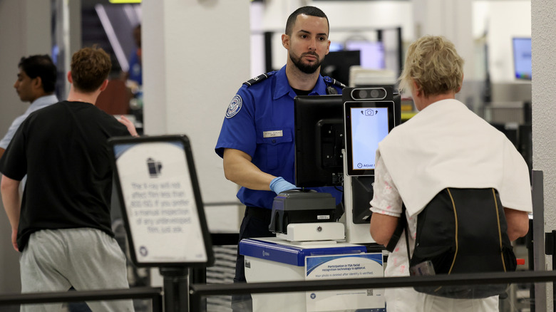 A TSA agent talking to a passenger in Miami, 2024.