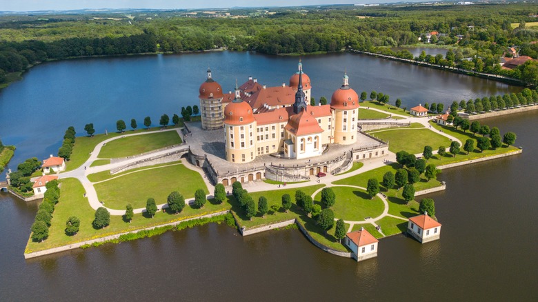 Moritzburg Castle surrounded by water in the lush green landscape of Saxony, Germany