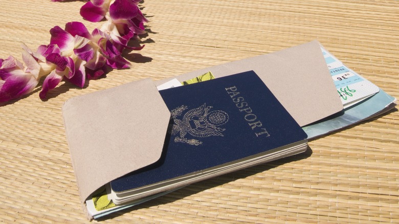 A passport, a plane ticket, and a leis