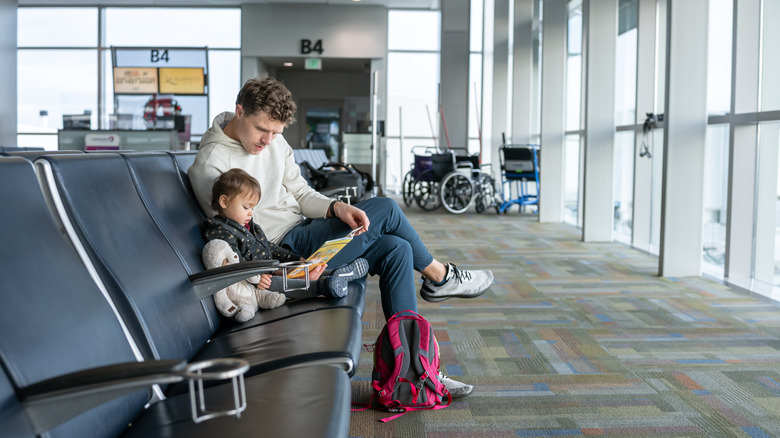 Dad reading to a child in the airport