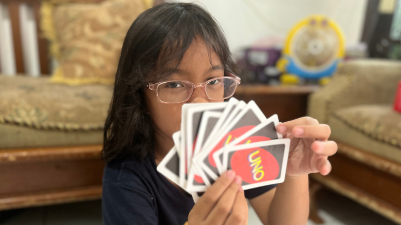 Little girl holding UNO cards