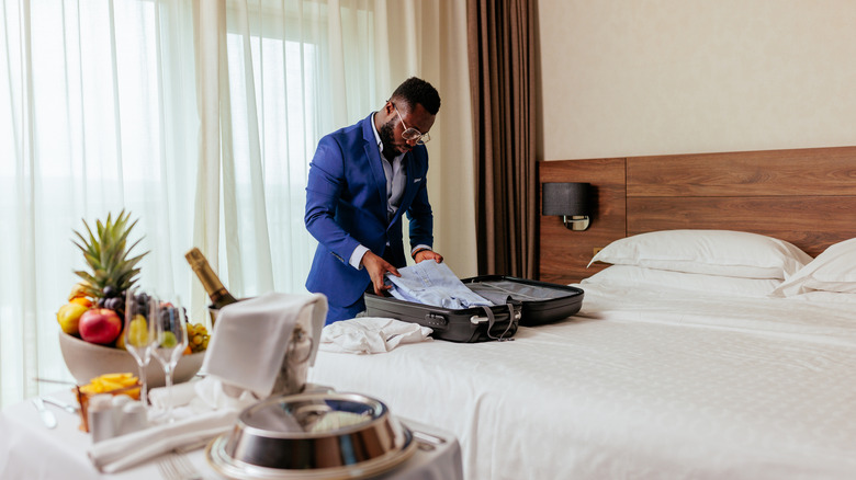 man unpacking with luxury hotel spread