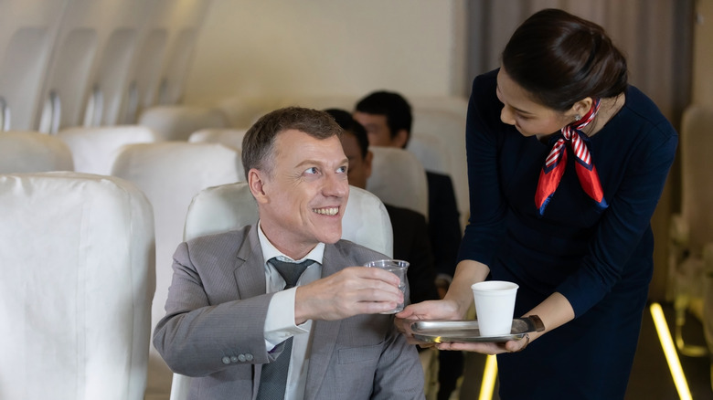 Man getting tea from a flight attendant