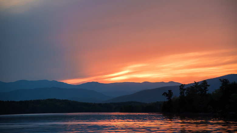 Low sun behind mountains and a lake in Morganton, North Carolina