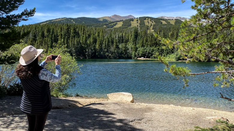 Woman takes photo of lake at Sawmill Reservoir.