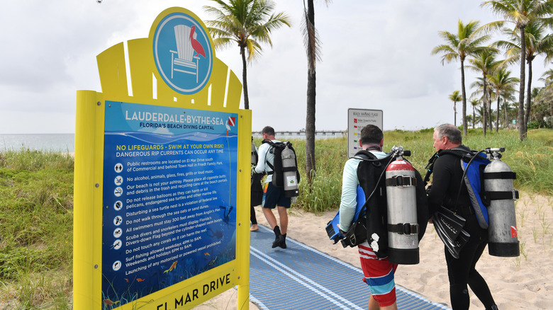 Scuba divers walking toward the beach in Lauderdale-By-The-Sea, FL