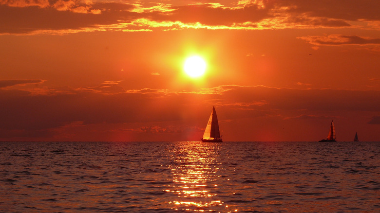 Bright sunset on the water with sailboat near Youngstown