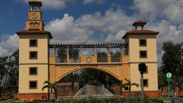 A yellow entrance gate of Hialeah with a fountain