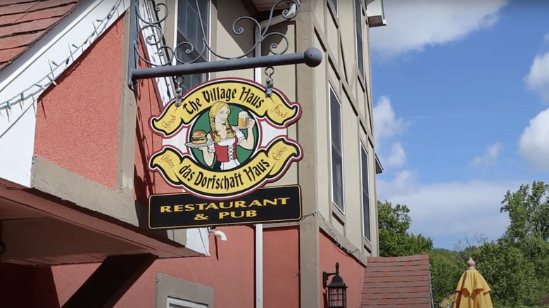 A hanging sign of The Village Haus in Stroudtburg.