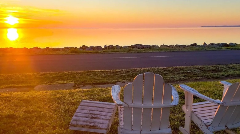 Two weathered chairs face sunrise over the Potomac River, Colonial Beach